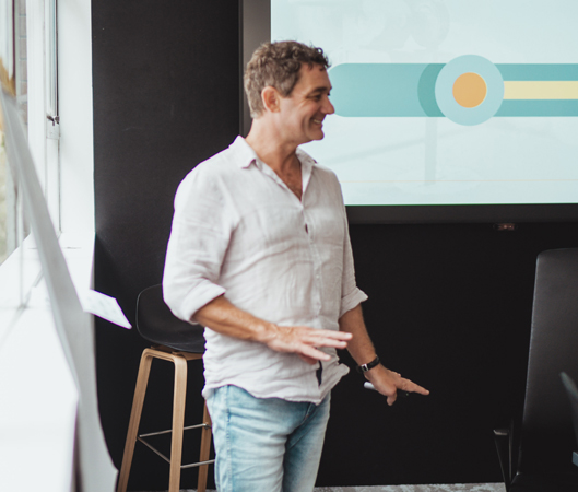 Man Presenting as a Business Coach for Your Tradie Business in a Modern Workspace.